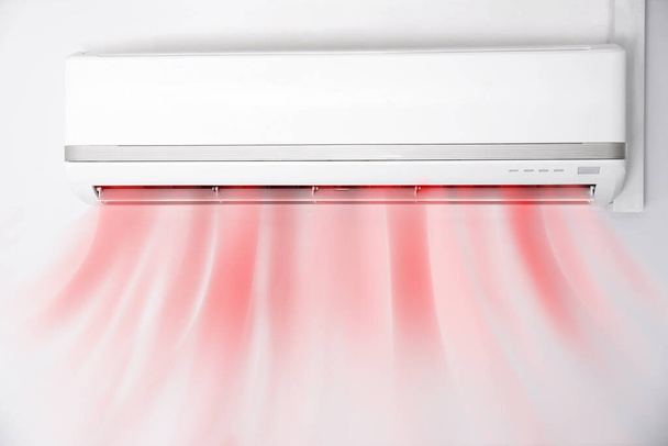 Modern conditioner and illustration of warm air flow on white wall indoors - Fotoğraf, Görsel