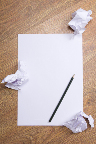 Lápis sobre clara papel de branco com bolas de crumble de papel na t de madeira - Foto, Imagem