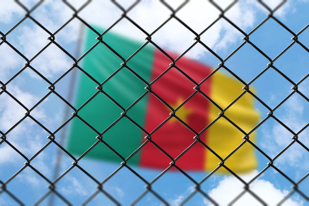 A steel mesh against the background of a blue sky and a flagpole with the flag of cameroon - Foto, immagini
