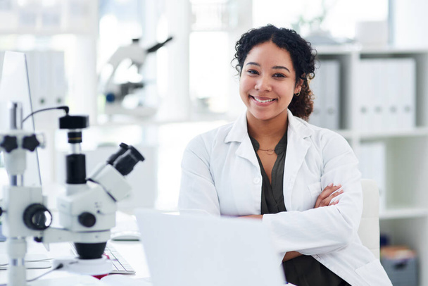 I love what I do. Portrait of a female scientist sitting with her arms crossed at her desk - Foto, imagen