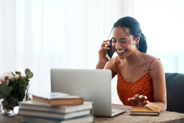 Це завжди приємно допомагати щасливим клієнтам. приваблива молода бізнес-леді сидить у своєму офісі і використовує свій ноутбук під час телефонного дзвінка
 - Фото, зображення
