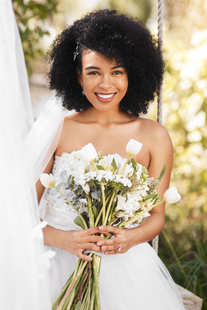 Every bride deserves to look perfect on her wedding day. Portrait of a happy and beautiful young bride holding a bouquet of flowers while posing outdoors on her wedding day - 写真・画像