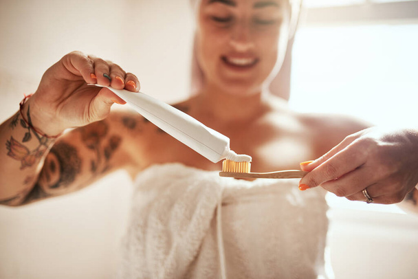 Правая зубная паста все меняет. молодая женщина чистит зубы в ванной комнате дома - Фото, изображение