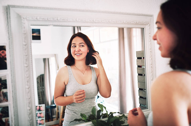Im living for the way I look right now. an attractive young woman admiring herself while standing in front of the mirror in her bedroom at home - Fotoğraf, Görsel