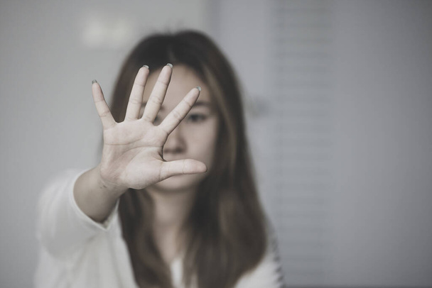 Stop geweld tegen vrouwen, vrouw die haar gezicht bedekt in angst voor huiselijk geweld, donkere Toon - Foto, afbeelding