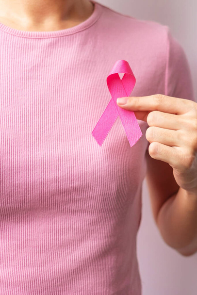 Pink October Breast Cancer Awareness month, woman hand hold pink Ribbon and wear shirt for support people life and illness. National cancer survivors month, Mother and World cancer day concept - Fotoğraf, Görsel