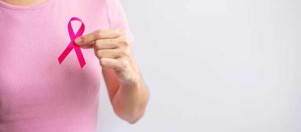 Pink October Breast Cancer Awareness month, woman hand hold pink Ribbon and wear shirt for support people life and illness. National cancer survivors month, Mother and World cancer day concept - Foto, immagini