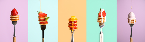 Set of forks with sweet mini pancakes and strawberry on color background - 写真・画像