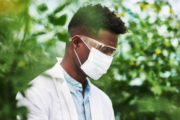 You first have to protect yourself against plant allergies. a young botanist wearing protective eye and face gear while working outdoors in nature - Photo, Image