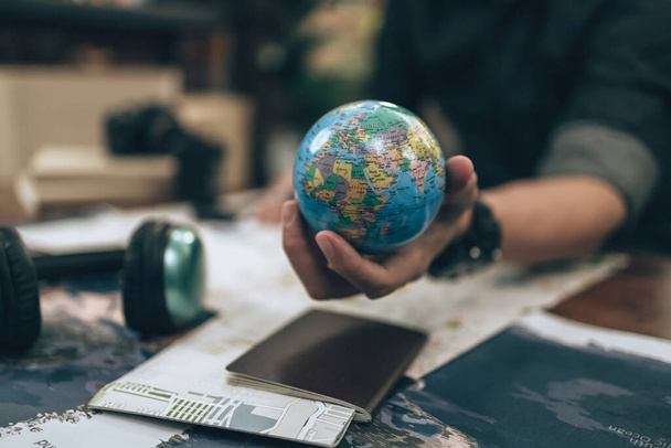 Globe, whole world in hands and compass, magnifying glass and book on route map on the table. Travel , Adventure and Discovery concept. - Foto, immagini