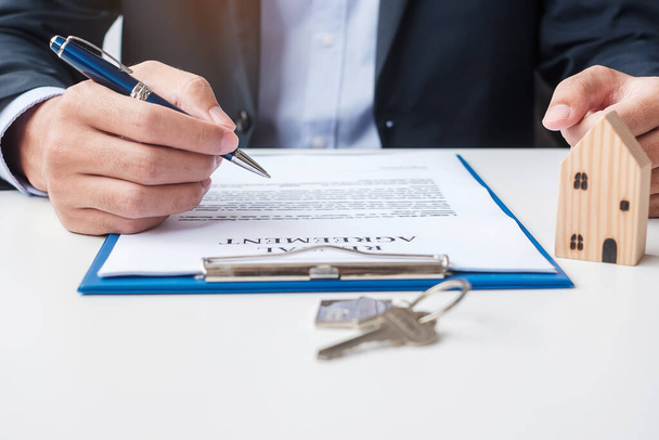 Mann unterschreibt Hausvertragsunterlagen. Vertragsabschluss, Immobilien, Kauf und Verkauf sowie Versicherungskonzepte - Foto, Bild
