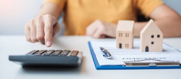 Woman using calculator during signing home contract documents. Contract agreement, real estate,  buy and sale and insurance concepts - Photo, Image