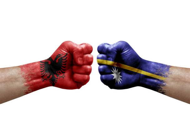 Two hands punch to each others on white background. Country flags painted fists, conflict crisis concept between albania and nauru - Valokuva, kuva