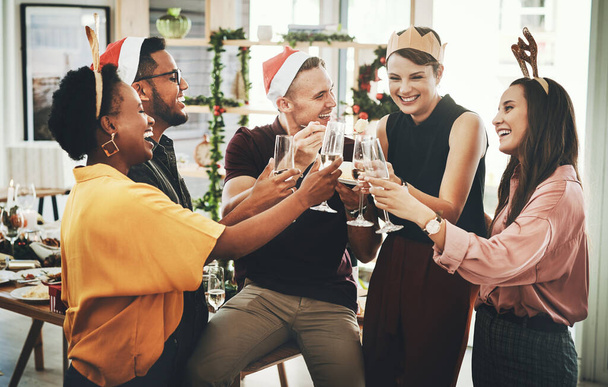 Це найщасливіший сезон. Група веселих молодих друзів виголошує тост під час святкування Різдва разом вдома. - Фото, зображення