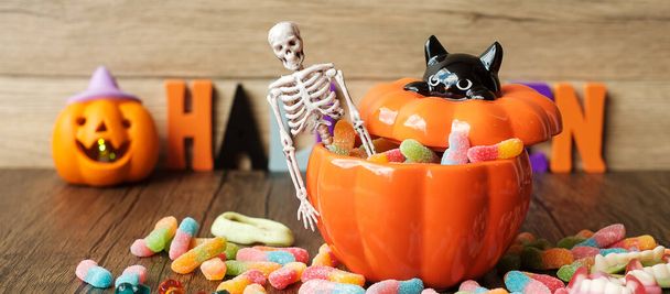 Χαρούμενη ημέρα του Halloween με καραμέλες φάντασμα, μπολ κολοκύθας, Jack O φανάρι και διακοσμητικά (επιλεκτική εστίαση). Trick or Threat, Hello Οκτώβριος, φθινόπωρο, Εορταστική, κόμμα και έννοια των διακοπών - Φωτογραφία, εικόνα