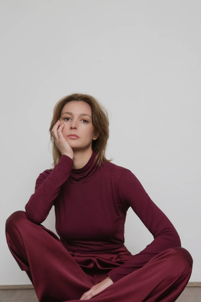 Serie of studio photos of young female model wearing all purple classic outfit, stretch viscose turtleneck and wide legged trousers. - Foto, immagini