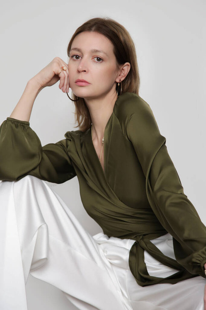 Serie of studio photos of young female model wearing pine green silk satin wrap blouse - Fotoğraf, Görsel