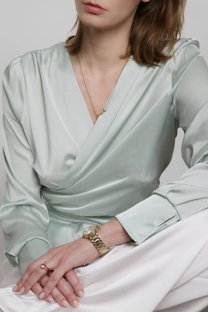 Serie of studio photos of young female model wearingmint green silk satin wrap blouse - Fotó, kép
