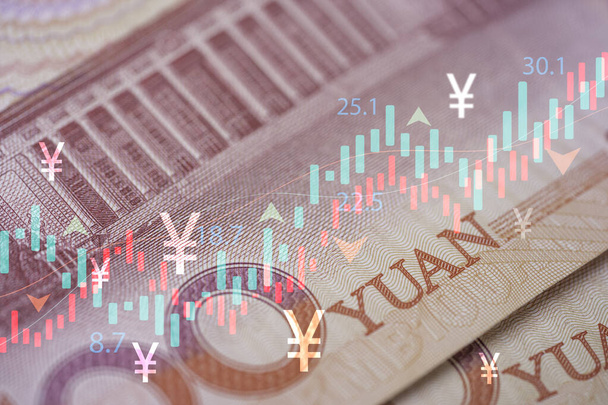 Heap of Yuan banknotes with stock market graph chart and Yuan symbol for Trading currency exchange and money transfer concept. - Foto, immagini