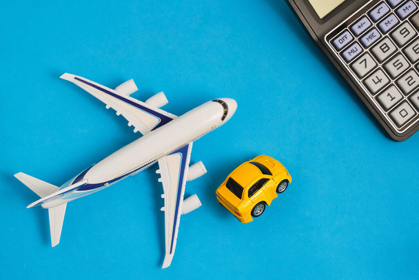 Calculator,model an airplane and car blue background. Concept costs expenses for air travel and transportation costs - 写真・画像