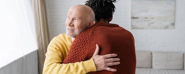 Θετικός παππούς αγκαλιάζει Αφροαμερικανό εγγονό στο σπίτι, πανό  - Φωτογραφία, εικόνα