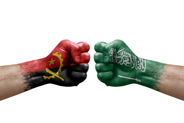 Две руки бьют друг друга на белом фоне. Флаги стран раскрашены кулаками, концепция конфликта между Анголой и Сауди Арабией - Фото, изображение