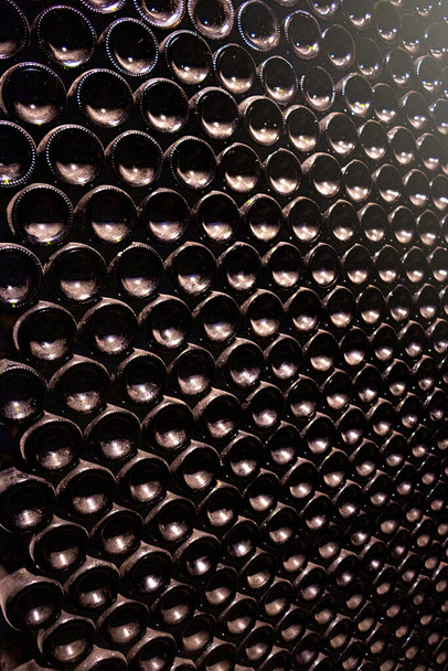 Bottles of red wine stacked in the wine cellar - Foto, Imagem