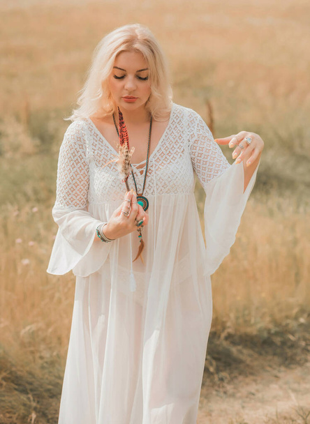 Ethnic hippie woman posing in boho long white lace dress at nature. Concept of ethnos style - Foto, Bild