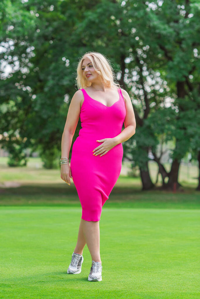 Plus size American blonde woman in pink midi dress at nature. Life of people xl size, happy nice natural beauty woman - Foto, Bild