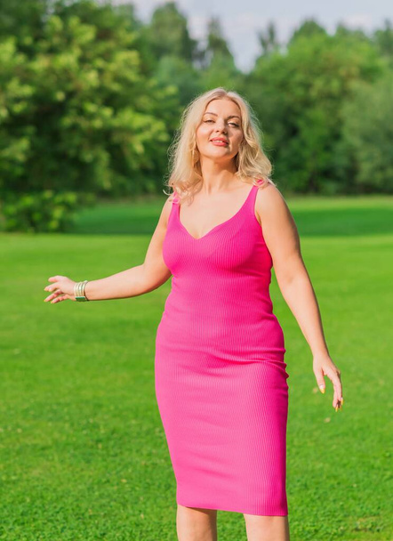 Plus size American blonde woman in pink midi dress at nature. Life of people xl size, happy nice natural beauty woman - Foto, immagini
