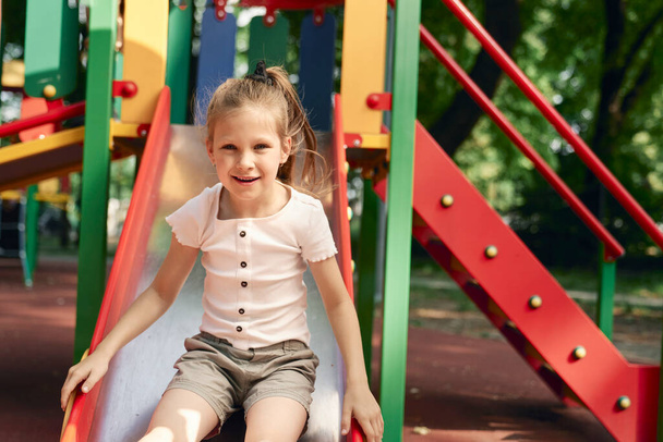Caucasian girl have fun at playground in sunny day  - Photo, Image