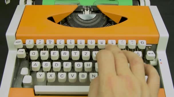 Hand typing ona a typewriter. Stylish orange vintage mechanical typing machine. White keyboard green paper. - Filmagem, Vídeo