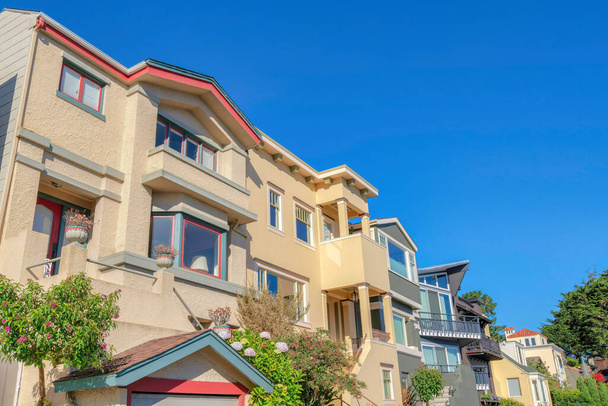 Низкий угол обзора домов с лестницей, ведущей к двери в Сан-Франциско, Калифорния. Слева - дом с пристроенным гаражом рядом с домом с балконами рядом с домом слева. - Фото, изображение