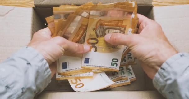 Руки беруть купу банкнот в 50 євро з картонної коробки. Вид зверху, пов. Концепція заощаджень, заощаджень, розбиття скарбнички. Високоякісні 4k кадри
 - Кадри, відео