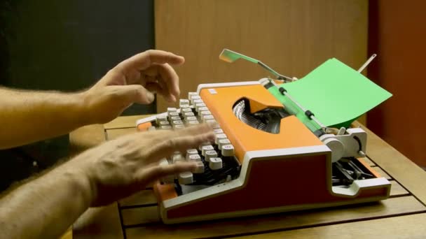 Male hands typing on a typewriter. Orange vintage mechanical old typing machine. Green paper white keyboard. - Filmati, video