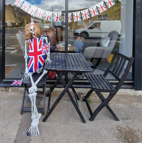 Αστεία διάταξη ενός σκελετού φορώντας περούκα και ένα Union Jack έξω από ένα καφέ στο Pudsey, Platinum Jubilee Γιορτές της Βασίλισσας της Αγγλίας τον Μάιο του 2022 - Φωτογραφία, εικόνα