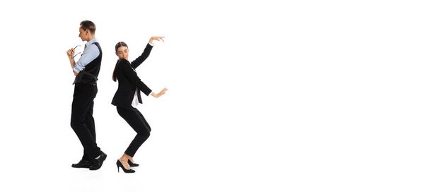 Портрет мужчины и женщины в официальной одежде на белом фоне. Женщина танцует за мужчиной. Концепция бизнеса, офисного образа жизни, успеха, балета, карьеры, самовыражения, рекламы. Flyer - Фото, изображение
