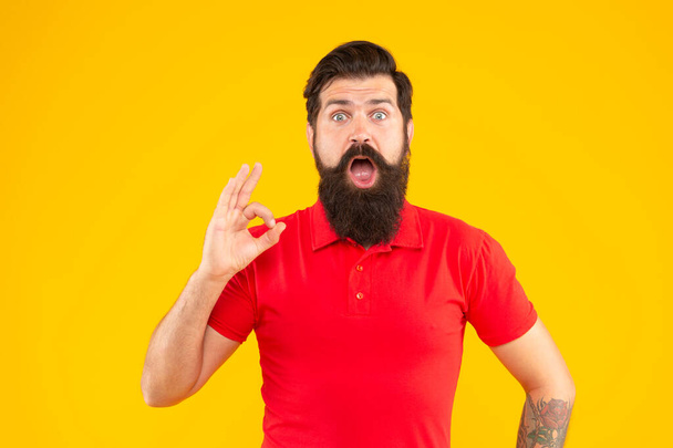 mature hipster with beard. brutal caucasian guy with moustache. confident and handsome bearded man on yellow background. hair and beard care. amazed male face portrait. ok. - Foto, Bild