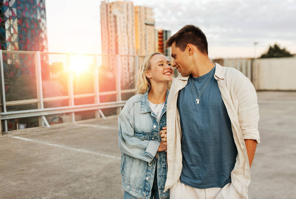 letní prázdniny, láska a lidé koncept - šťastný mladý pár objímání na střeše města - Fotografie, Obrázek