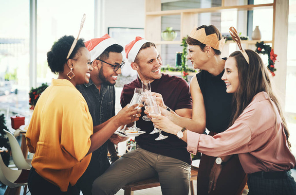 Cheers to the most wonderful time of the year. a group of cheerful young friends making a toast while celebrating Christmas together at home - Fotoğraf, Görsel