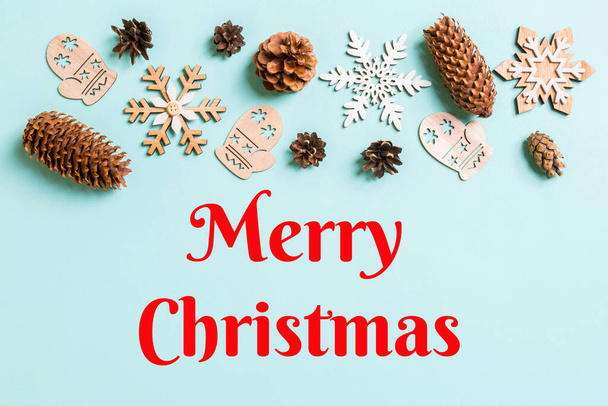 Merry Christmas text. Top view of holiday toys and decorations on blue Christmas background. New Year time concept with copy space. - Fotó, kép