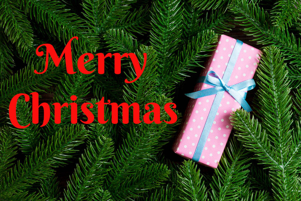Merry Christmas text. Top view of Christmas gift box on fir tree background. Time for holiday concept with copy space. - 写真・画像