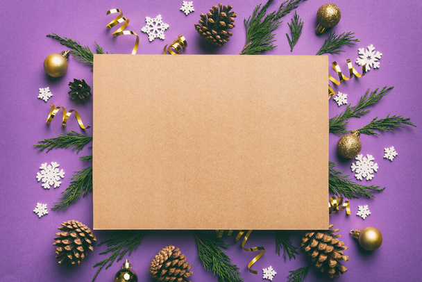 Flach lag die Weihnachtskomposition. quadratisches Papier blank, Tannenzweige, Weihnachtsschmuck auf farbigem Hintergrund. Ansicht von oben, Kopierraum für Text. - Foto, Bild