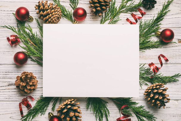 Flat lay Christmas composition. square Paper blank, pine tree branches, christmas decorations on Colored background. Top view, copy space for text. - Foto, immagini