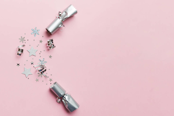 Christmas crackers with shiny confetti on color background, top view, copy space. - Photo, Image