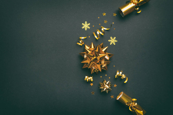 Weihnachts-Cracker mit glänzendem Konfetti auf farbigem Hintergrund, Draufsicht, Kopierraum. - Foto, Bild