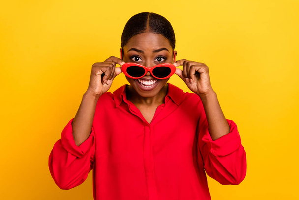 Photo of young excited pretty lady wow discount ads wear eyeglasses isolated over yellow color background. - Foto, imagen
