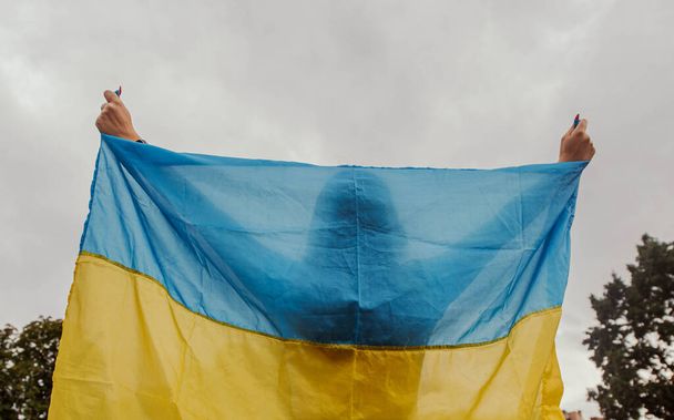 the girl is holding the flag of Ukraine. the concept of patriotism - 写真・画像