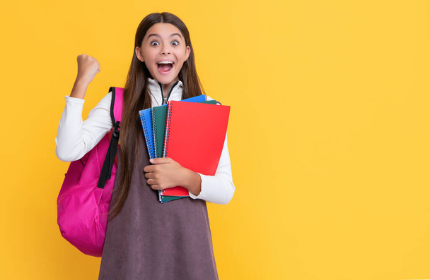 successful child with school backpack and workbook on yellow background. - Valokuva, kuva