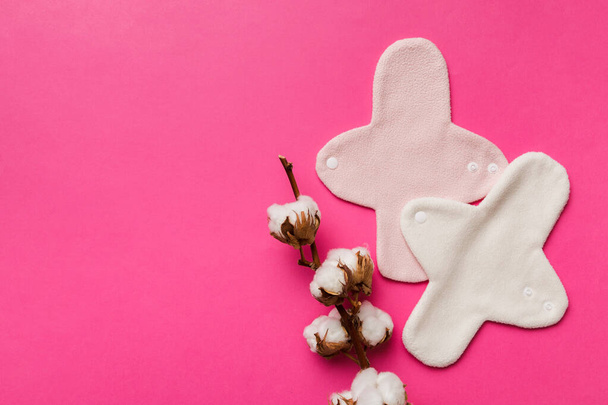 set van kleurrijke heldere herbruikbare menstruatiepads met katoenen bloem. nul afval vrouw periodes concept top view met kopieerruimte. - Foto, afbeelding